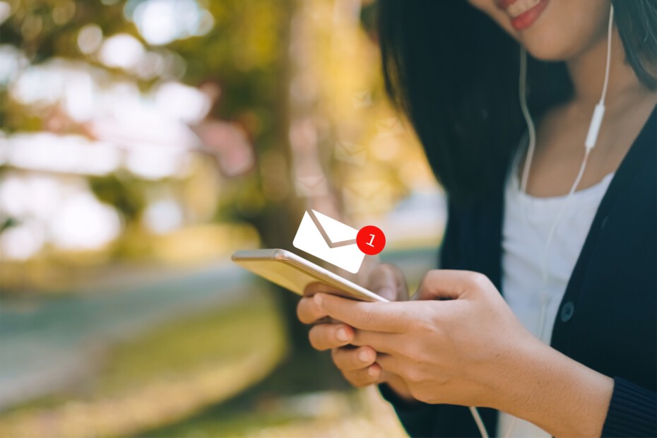 Woman hand using smartphone to send and receive email.